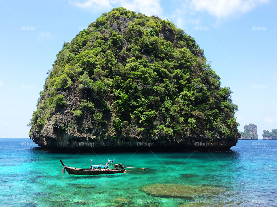 Green tropical island in turquoise sea water 