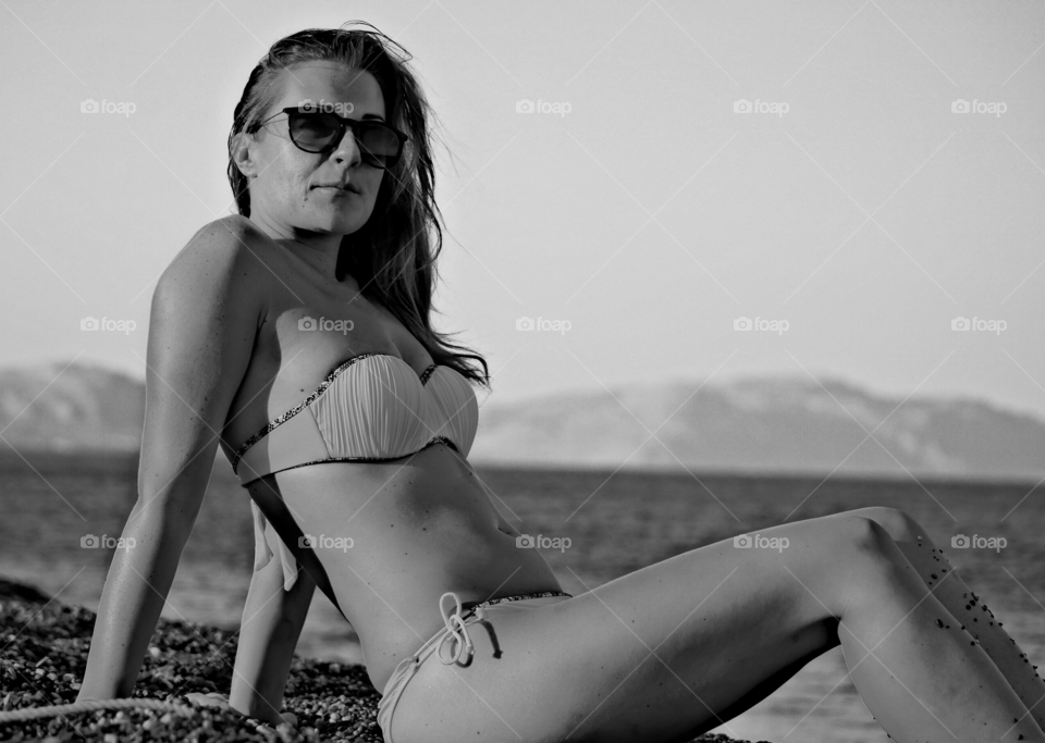 Woman in bikini sitting at beach