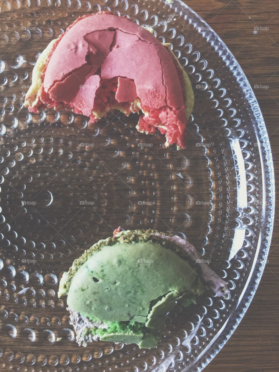 Two half eaten macaroons on a plate