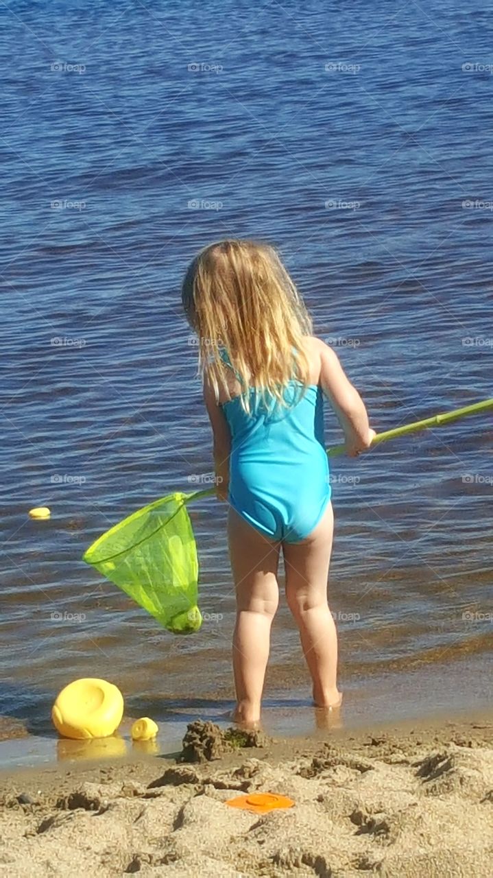 Girl on the beach with a landing net