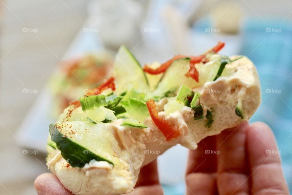 Salmon spread with thinly sliced cucumber, red pepper, and green onion on toasted bagel 🥯