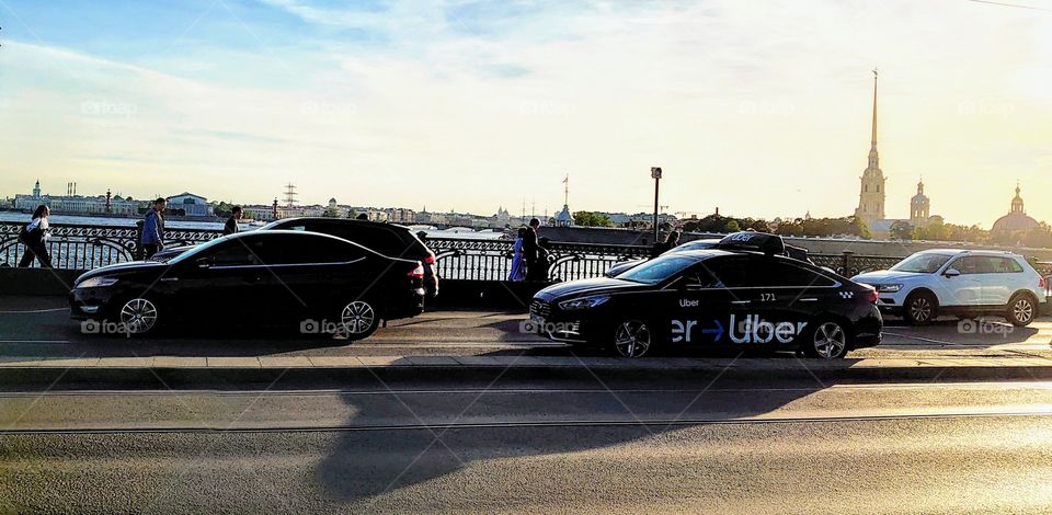 Uber car on Troitsky Bridge in front of the Peter and Paul Fortress in St. Petersburg, Russia