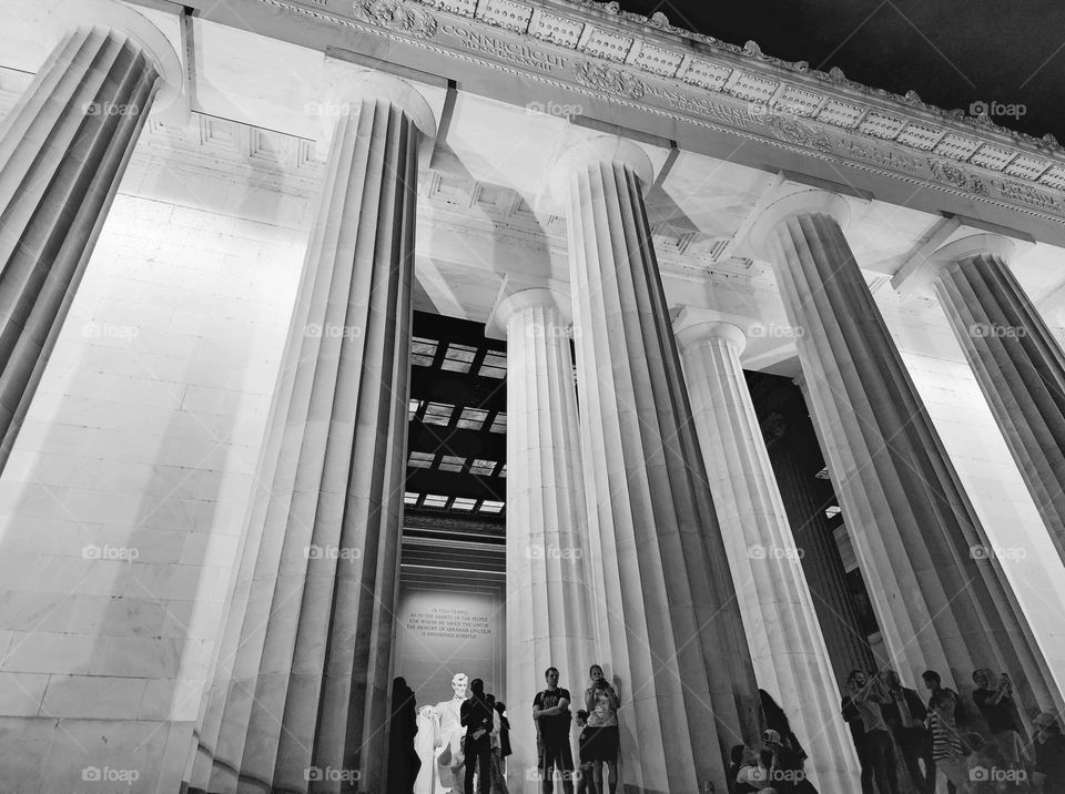 Tourists gather by the enormous pillars of the Abraham Lincoln Memorial in Washington DC on a summer evening
