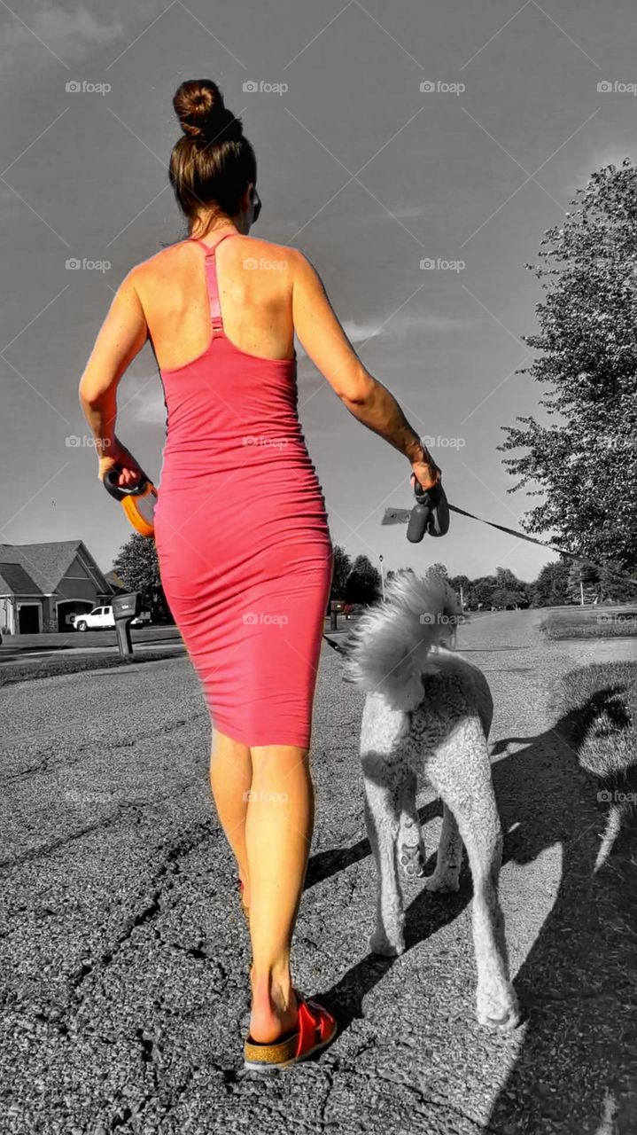 color spot of woman walking dog in tight dress