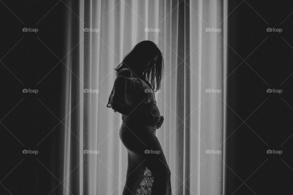 Beautiful silhouette of a pregnant woman at home