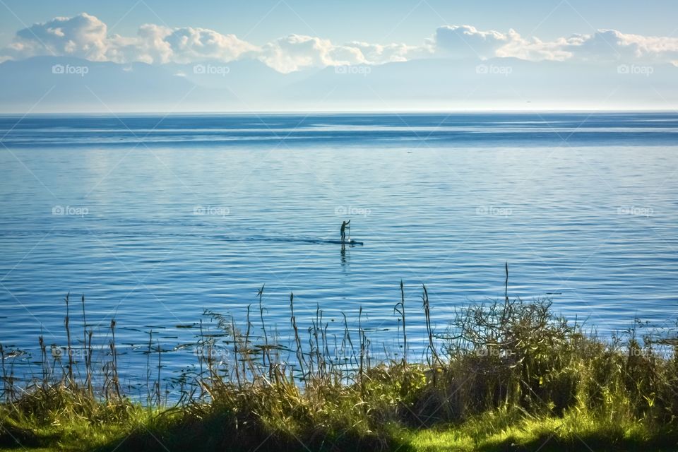 Man on paddleboard in the vast expanse of the Pacific Ocean - people on the west coast of North America 