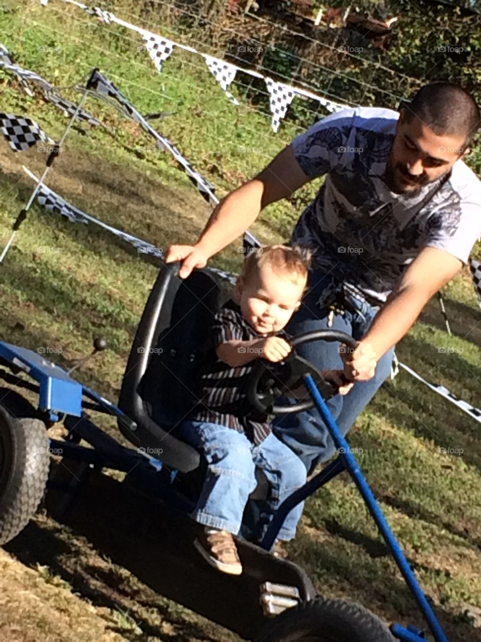 Boy having dad push him in go carts 