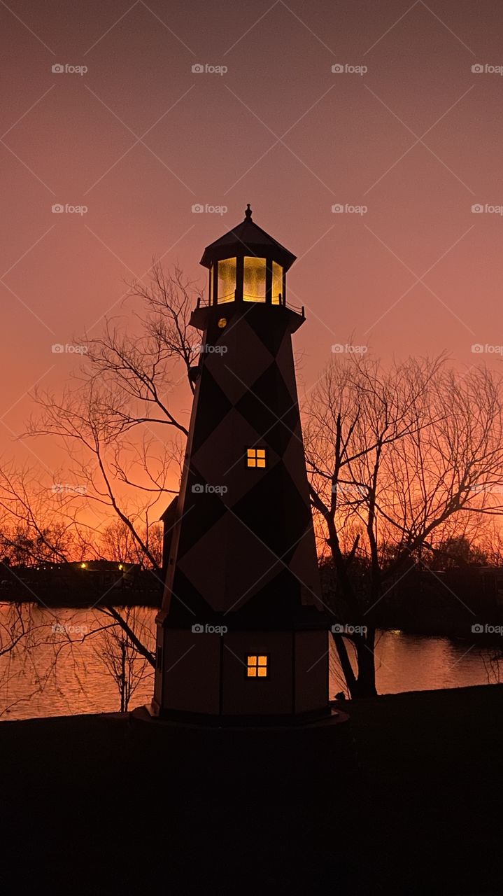 Lighthouse stands Firm all lit up for the Evening. Absolutely great Colorful Backlit Twilight makes the Horizon Shine Bright. 