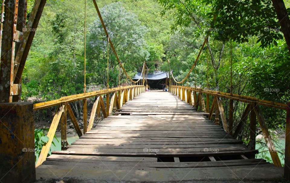 Travel the road less traveled. Yellow bridge that opens the doorway to the breathtaking Semuc Champey an endless maze of natural limestone caves.