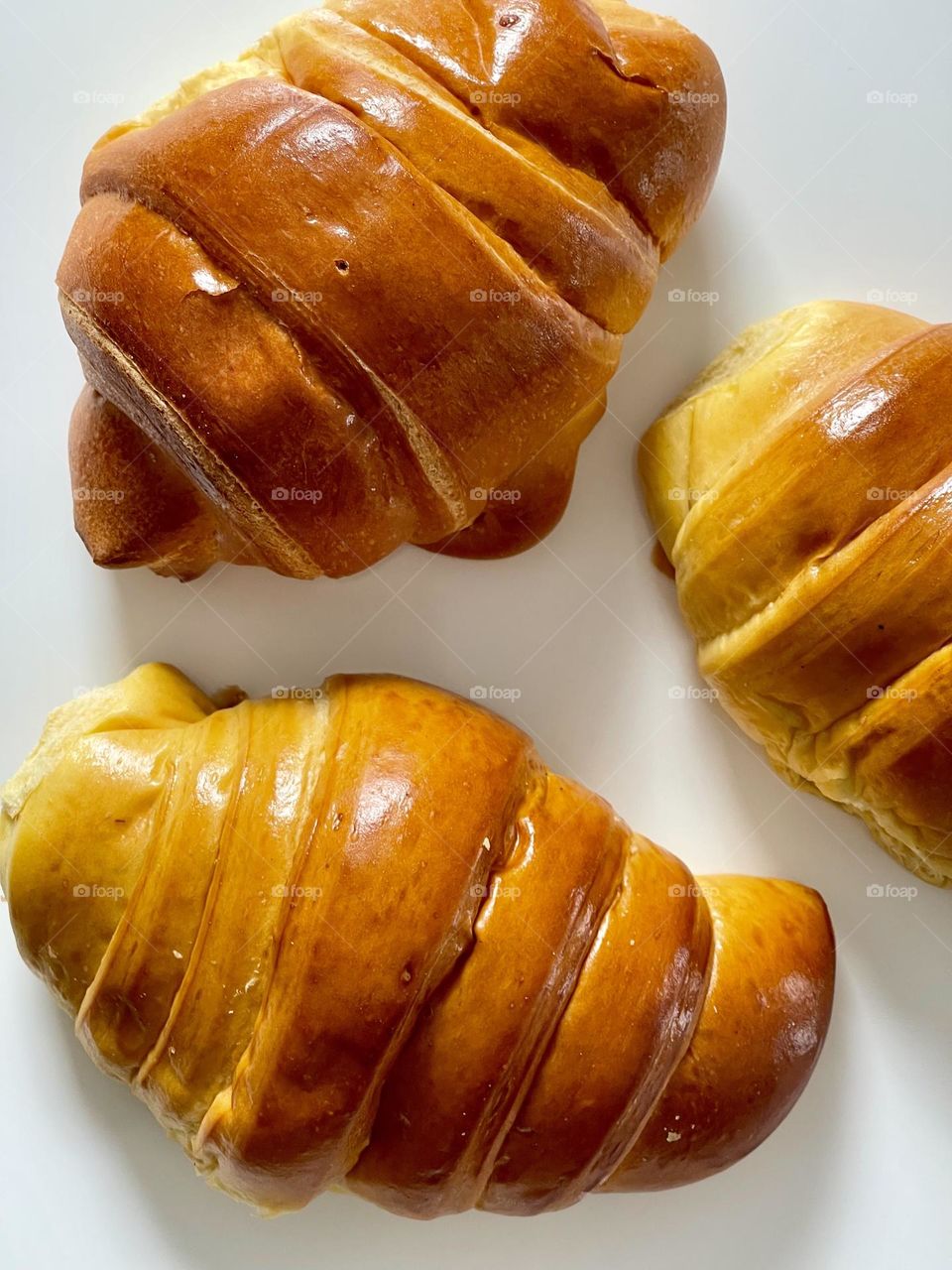 Yummy, delicious, freshly baked croissants seen from above against clear white background 