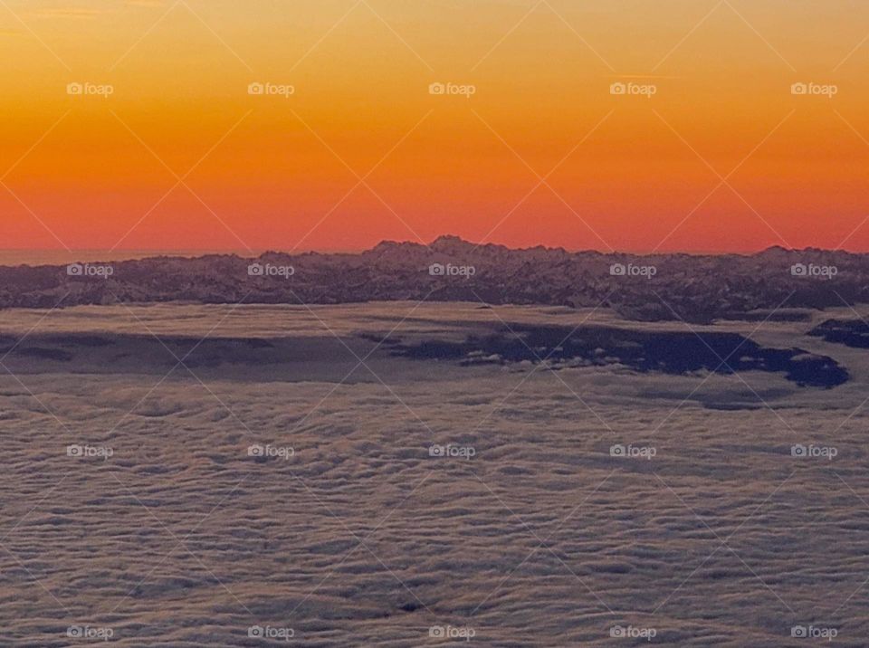 Washington state's Cascade mountain range pops through low clouds during a beautiful sunset