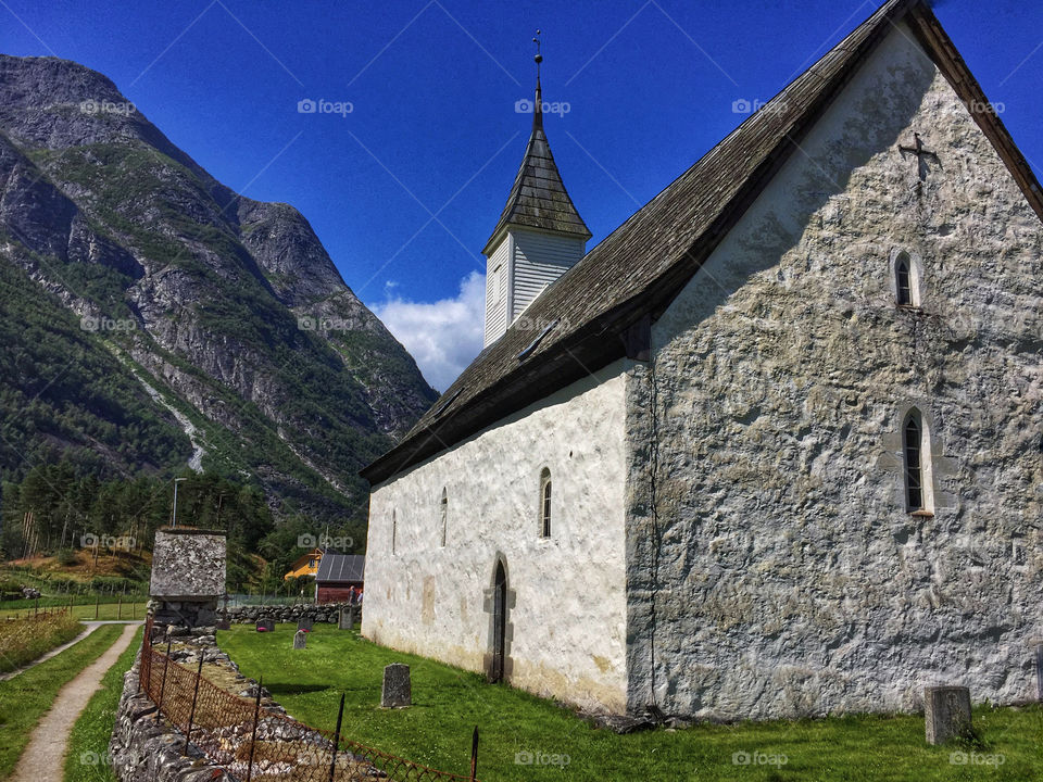A country church beside a mountain in a fjord valley in Eidfjord, Norway 