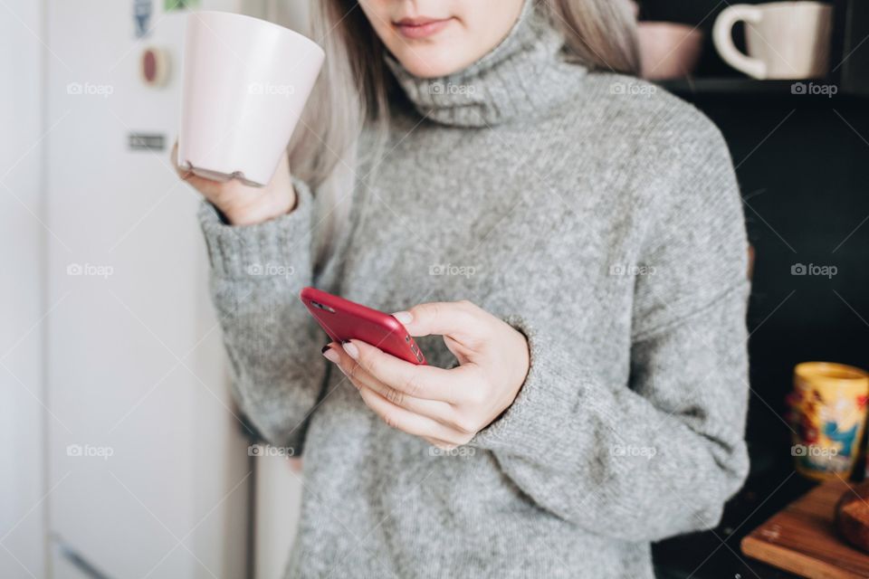 Girl drinking coffee and using mobile