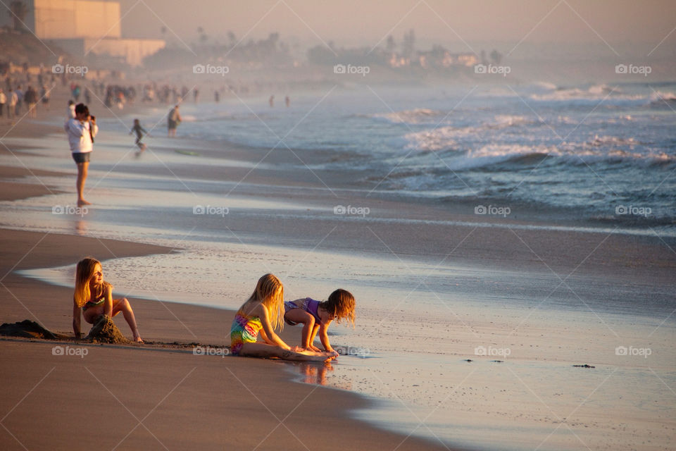 Two young girls playing on the beach in sunny California
