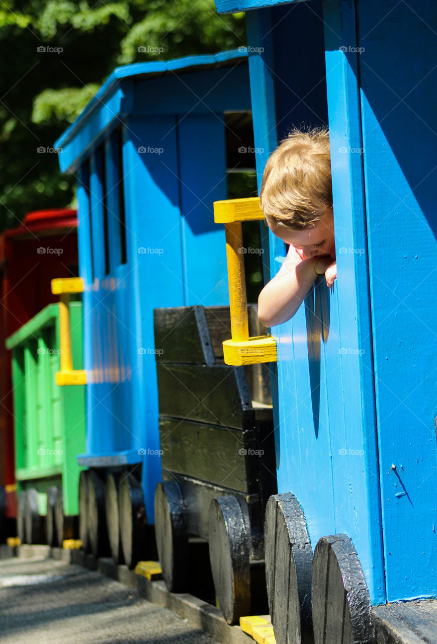 A young boy checks out a playground train