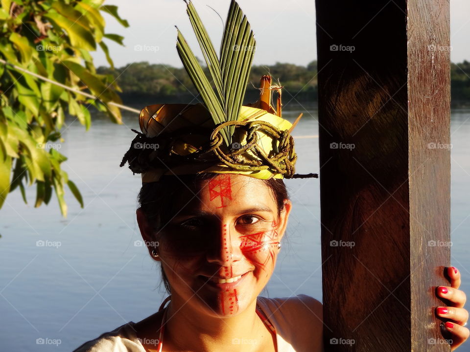 Palm and vine crown, native amazon face paint woman. Amazon river, near Iquitos Peru.