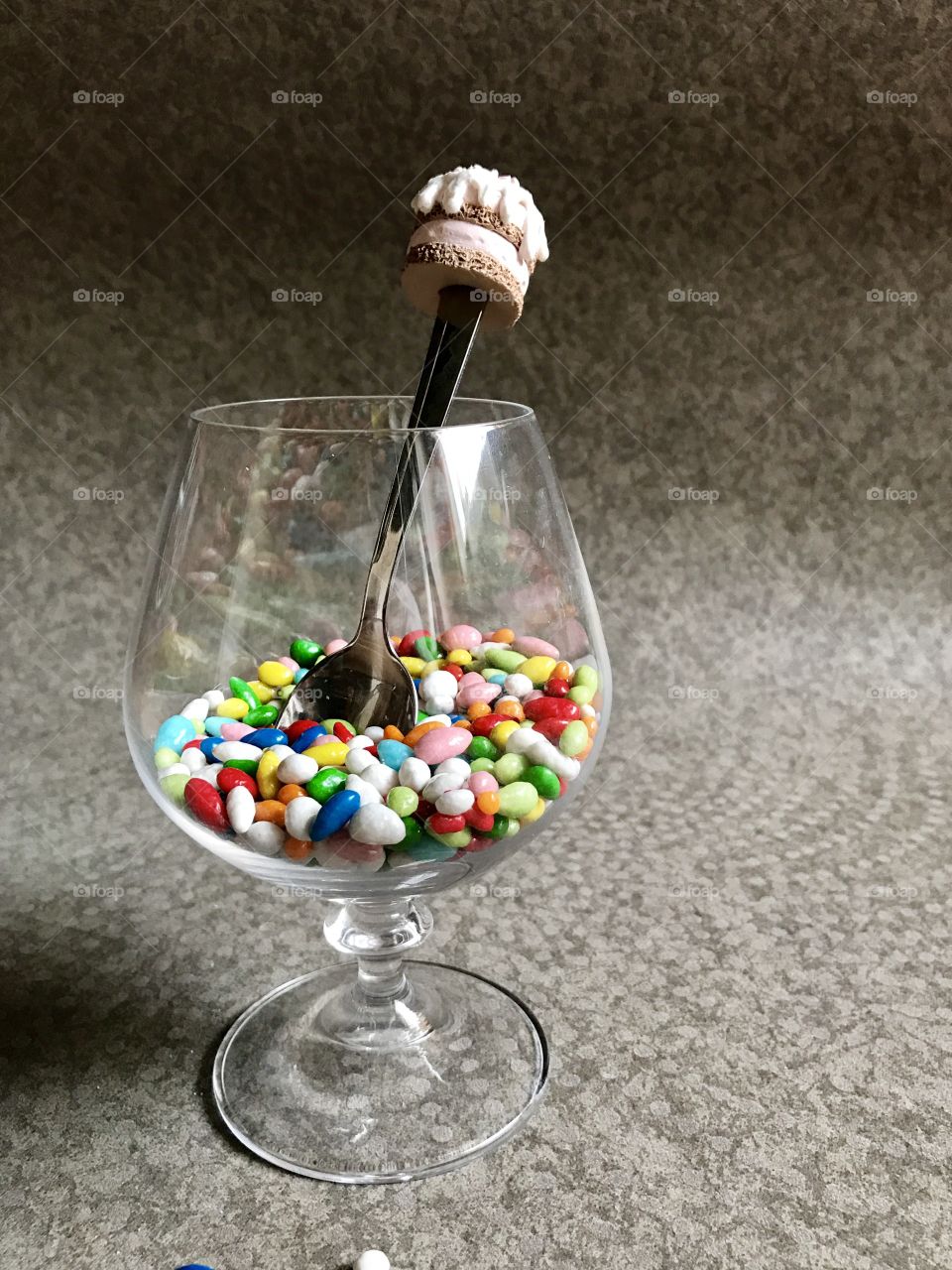 Multicolor candy in glass on grey background 