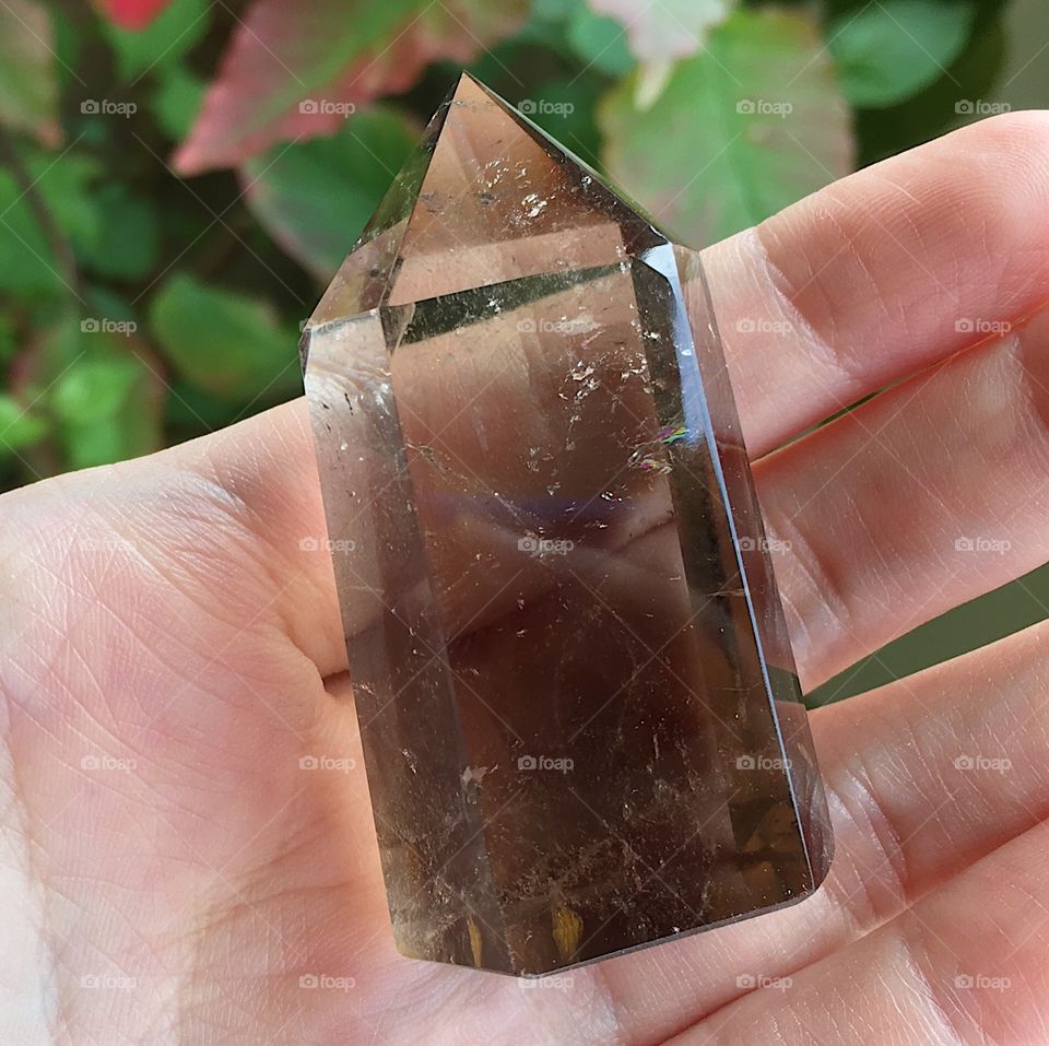 A polished smoky quartz crystal point.