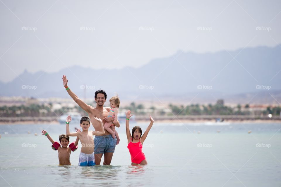 father and with his kids in the sea