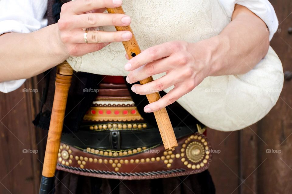 Young man dressed in Bulgarian traditional clothing (nosiya) playing bagpipes