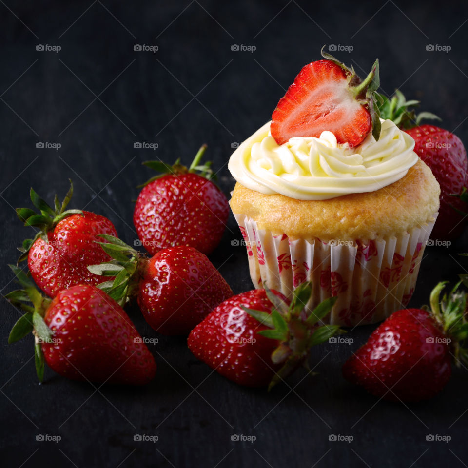 Close-up of a strawberry cupcake on black background
