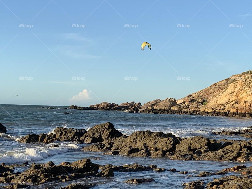 Kitesurfing on sea against coast 