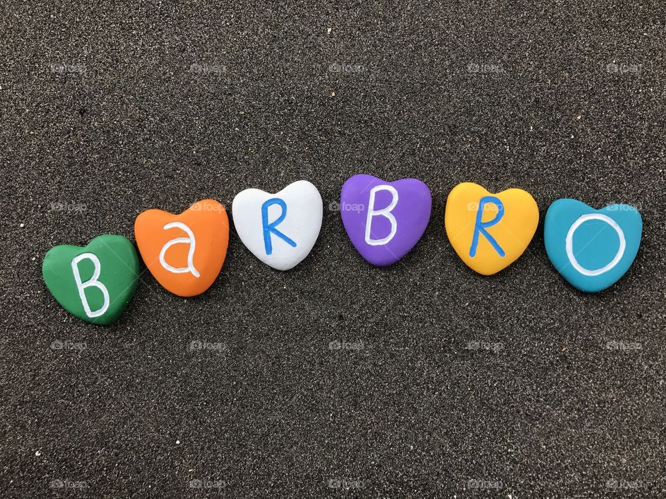 Barbro, female scandinavian name with colored heart stones over black volcanic sand