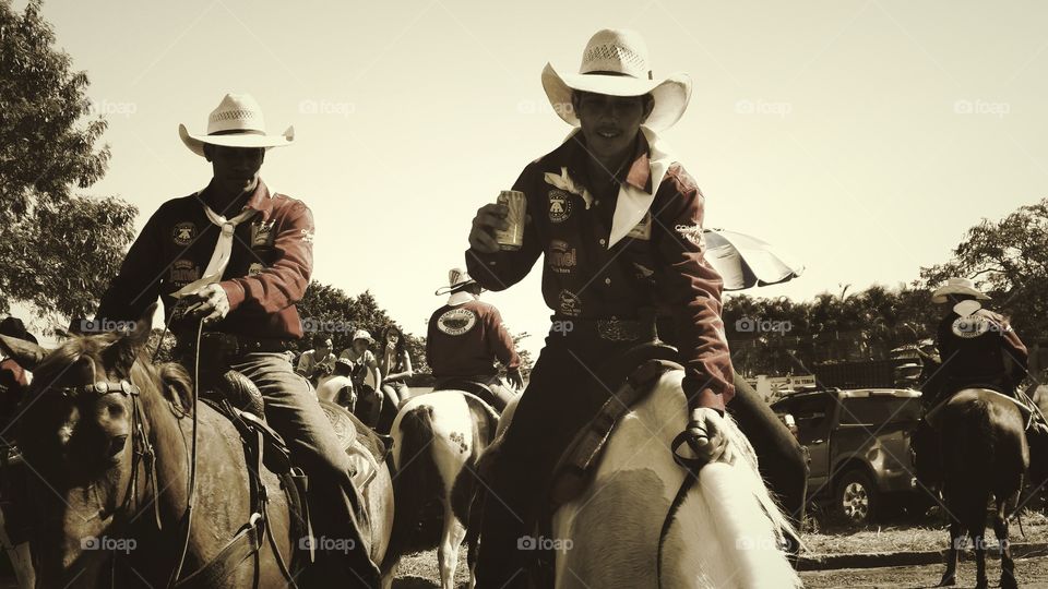 Cavalos, touros e cavaleiros. Confraternização, cavalgada nas ruas. Evento agropecuario tradicional comemorativo de aniversario de cidade brasileira. Cowboys e Cowgirls.