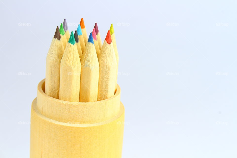 Group of color crayons in a wooden cylinder isolated macro