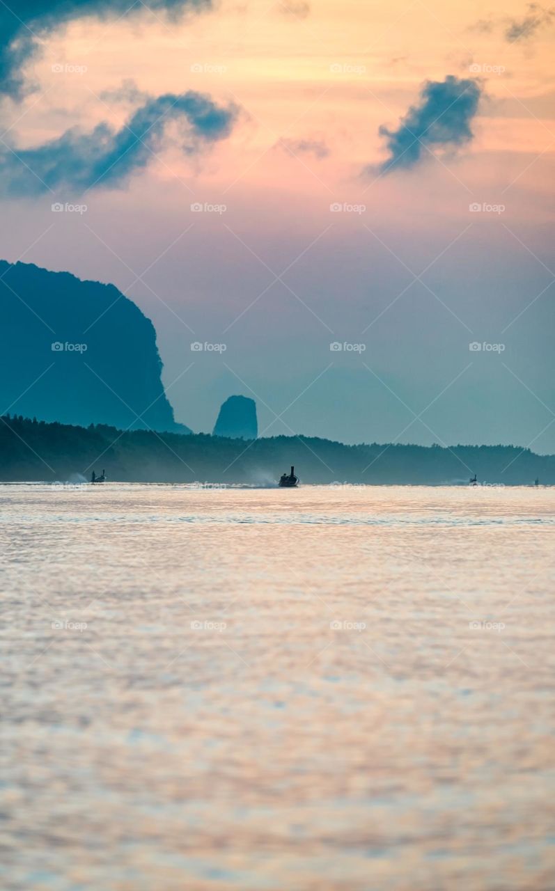 Beautiful Sunrise moment above silhouette of boat in sea