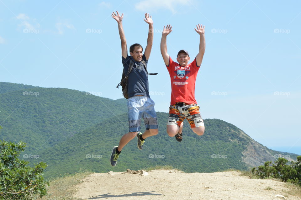 the guys jumping joyfully raised their hands and smiling. tourist. friendship. joy. emotions. bounce. motion
