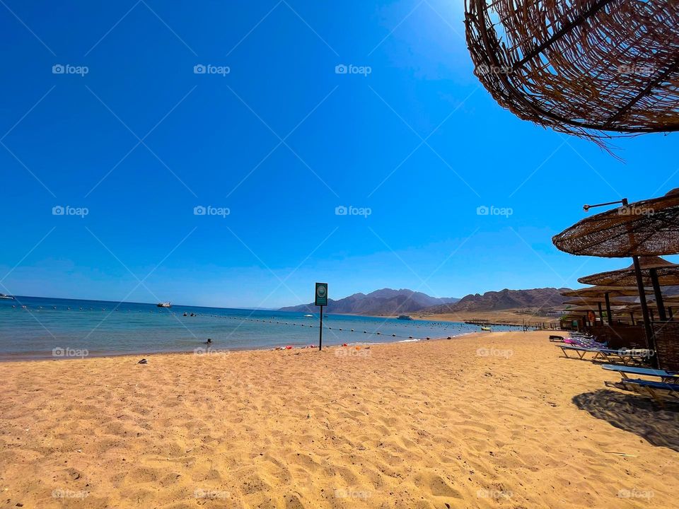 Summertime vibes. A sandy beach on the Egyptian city of Dahab, on the Gulf of Aqaba, Red Sea.