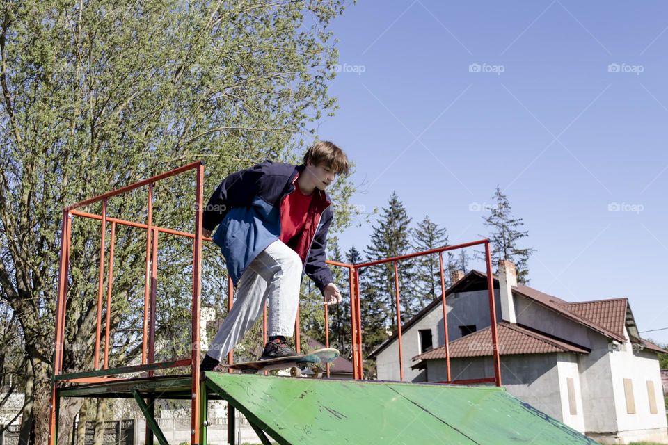 Hobbyist teenager goes in for sports, has fun and rides a skateboard in the park outdoors.