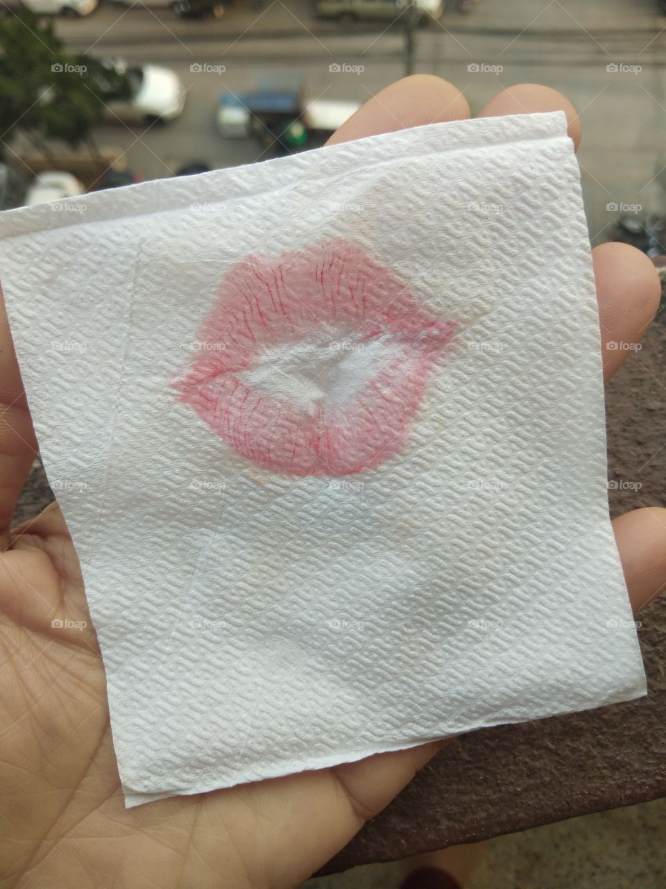 Close up of lip print with red lipstick on the napkin, lipstick kiss on white background.