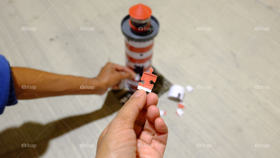 Boy putting jigsaw puzzle on lighthouse