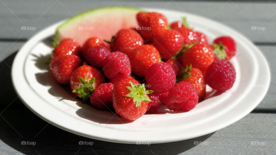 Fresh strawberries raspeberries in fair weather