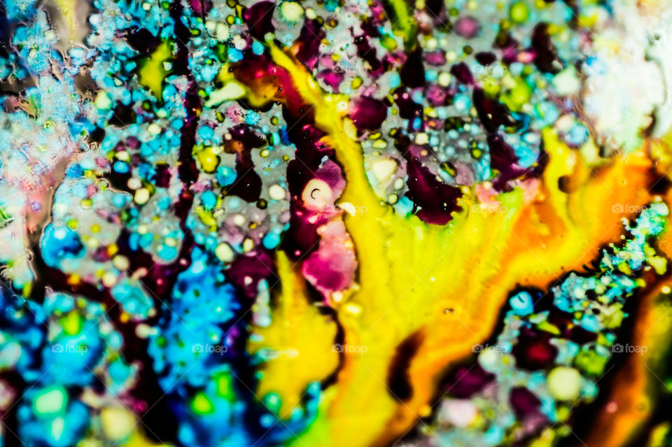 The ink to refill the printer cartridge was spilled onto the white washbasin and the paints blended into abstract drips and patterns.