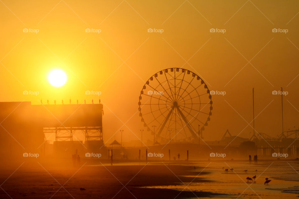 A beautiful golden sunrise slowly burns off the morning fog on the beach