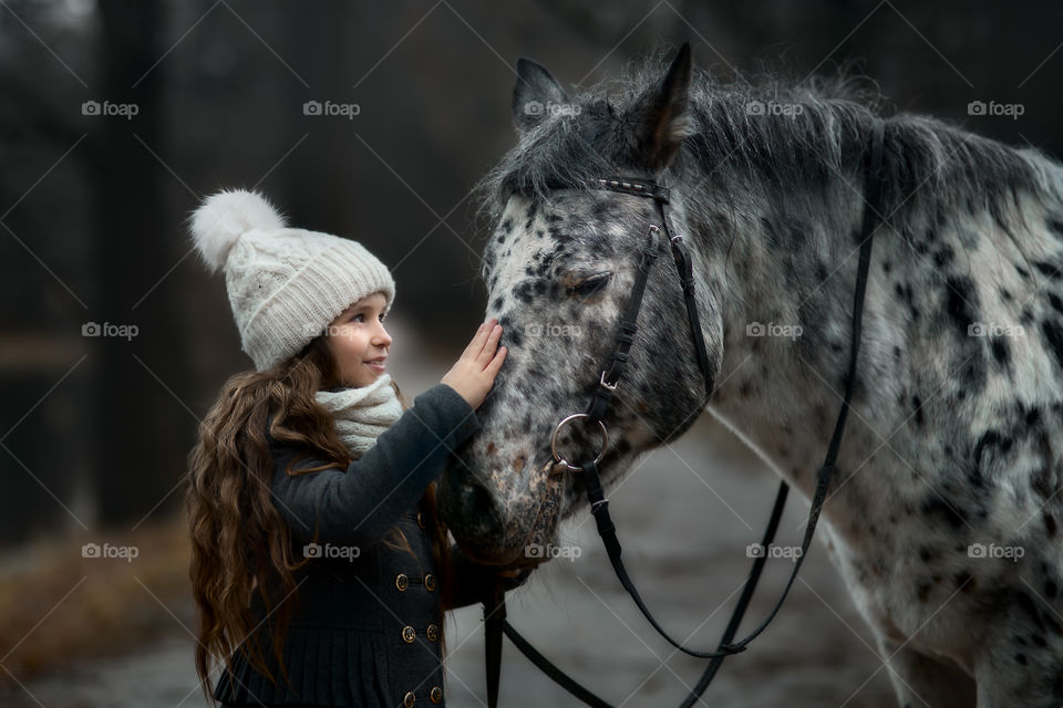 Twins girls with Appaloosa horse in autumn park 