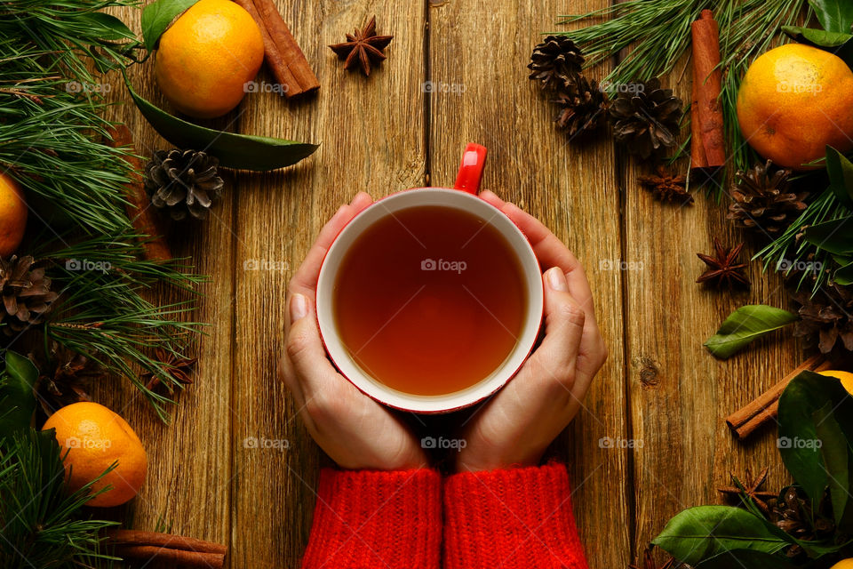 Girl holding cup of tea, Christmas style.