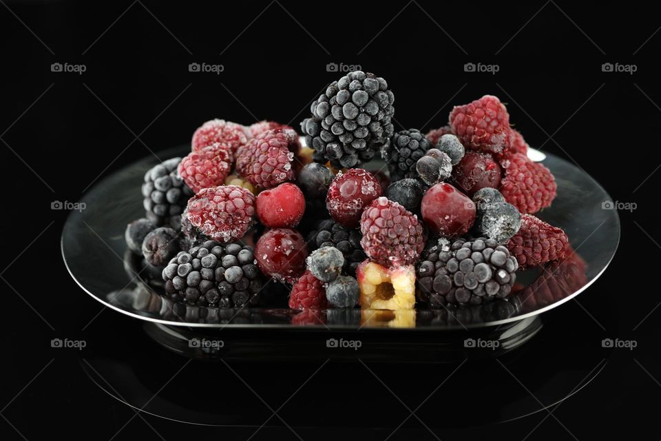 Frosted summer berries on black background