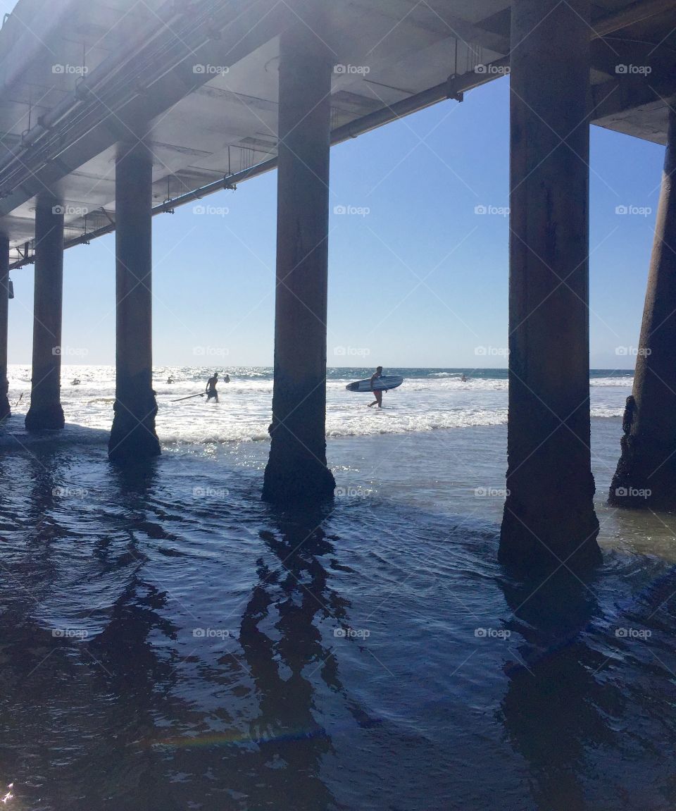 Looking at the surfers through the pier