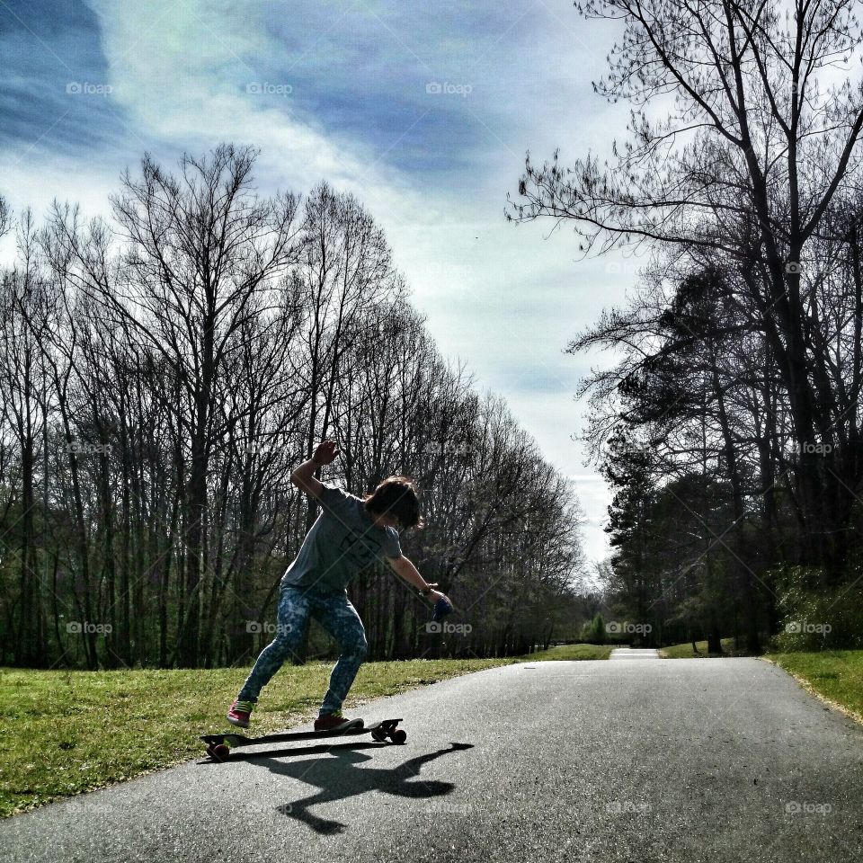 boarder enjoying hills off park trail. serendipity a skate boarder skidded of the path and into my shot. hardware filer