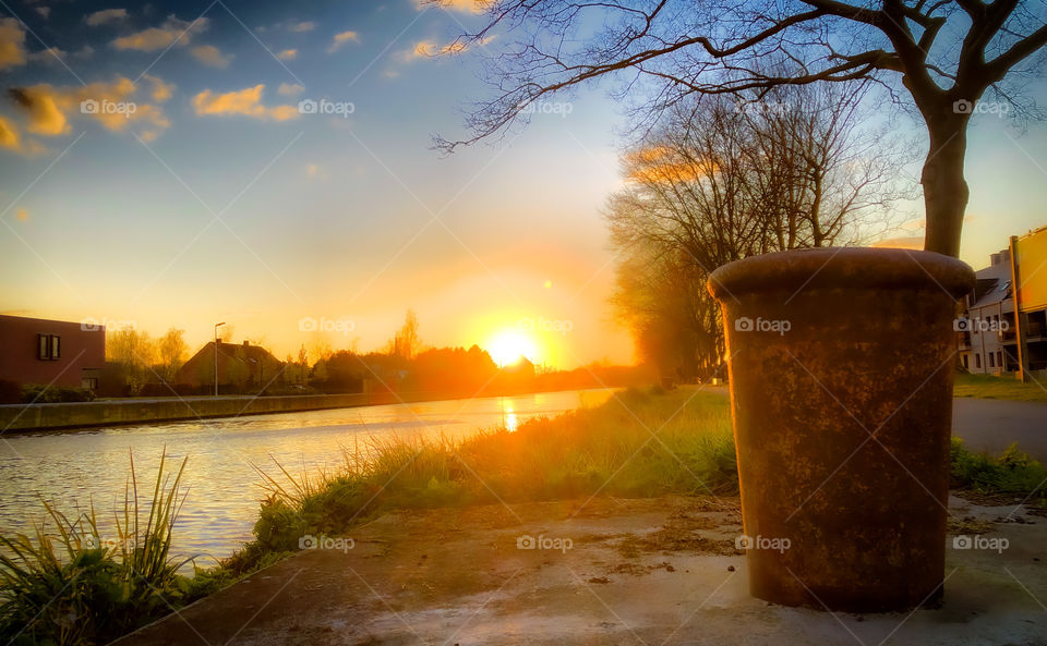 Rusty boulder on the riverside under a golden blue sunset sky