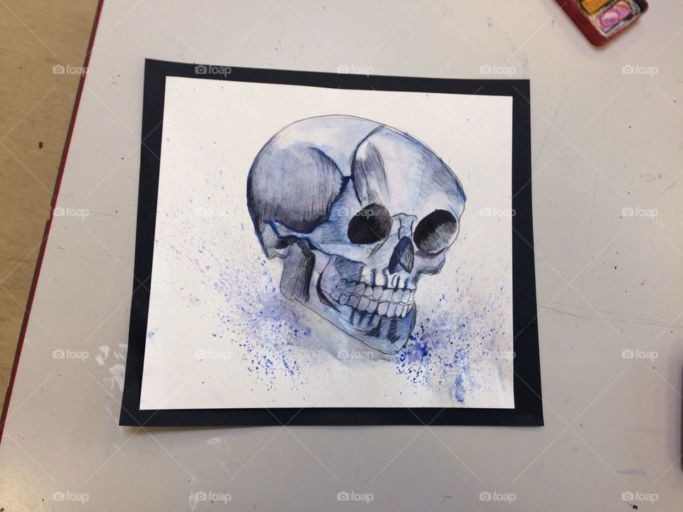 Blue and black pen and watercolour sketch of a human skull.