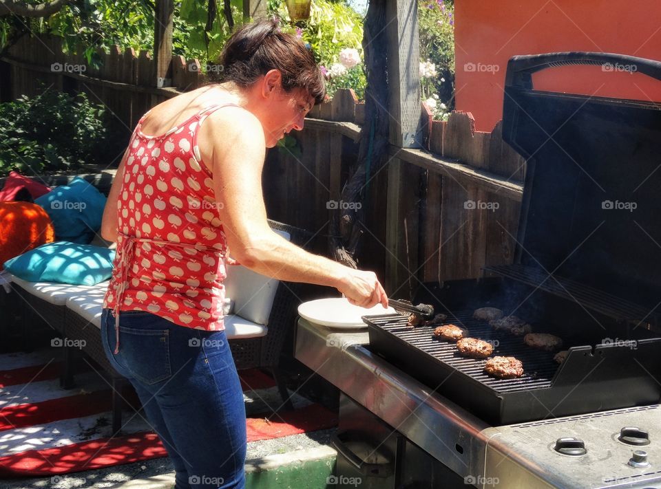 Woman Cooking Meat On The BBQ