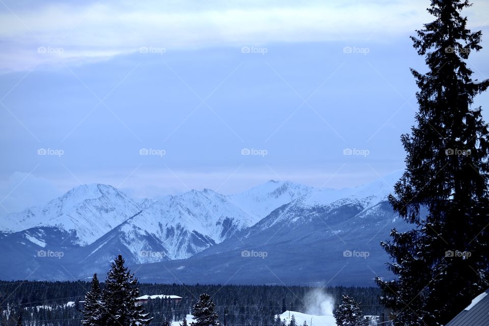 View of the snow covered mountains from the valley in autumn.