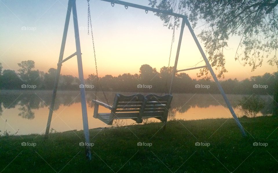 Empty swing in front of lake