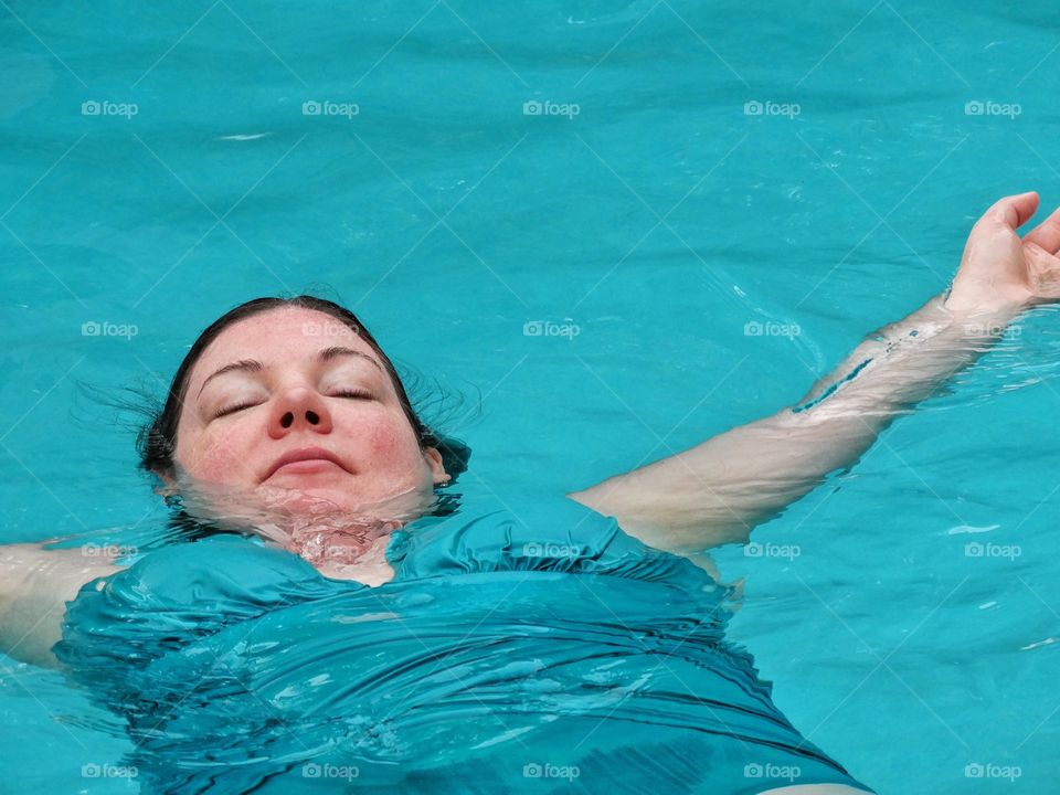 Lounging In The Pool. Woman Relaxing In Turquoise Water Of A Pool
