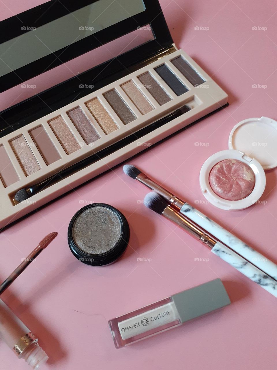 I love makeup and I love how beautiful I feel when I am wearing it. In this photo is some of my favorite makeup products set against a pastel pink background.